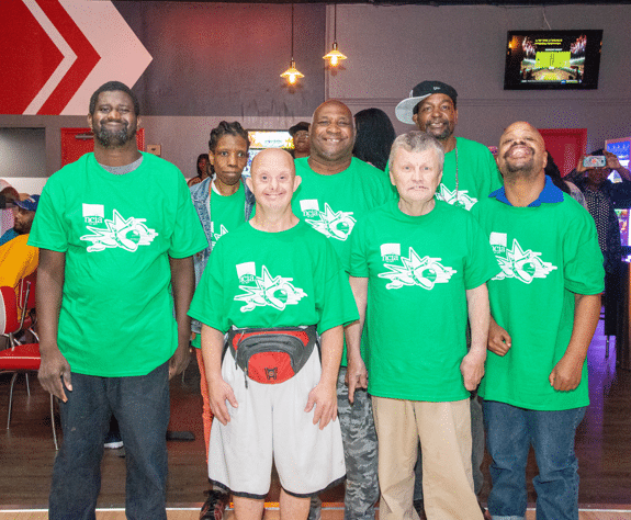 a group of people standing together in green shirts