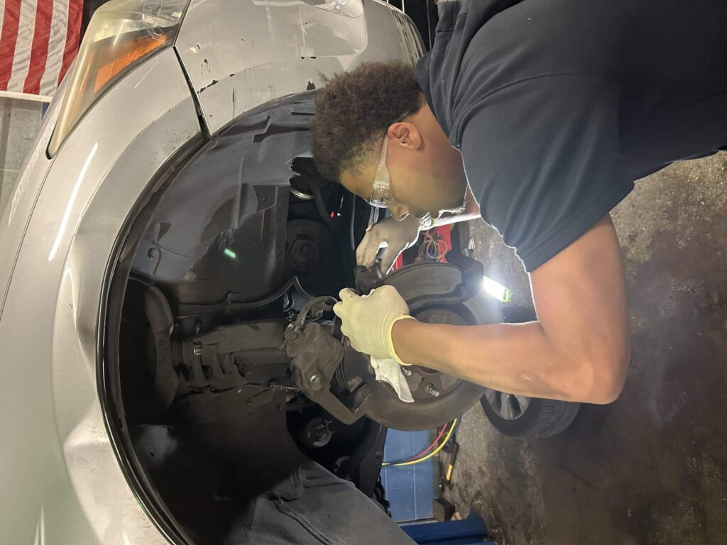 a man fixing a car wheel at automative shop